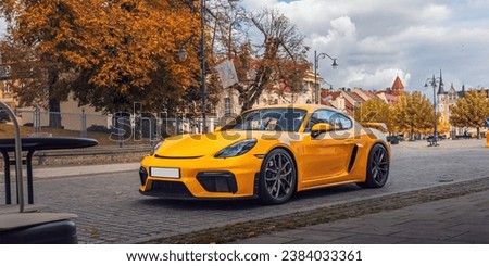 Yellow sports car parked in the center of old town near the street cafe Royalty-Free Stock Photo #2384033361