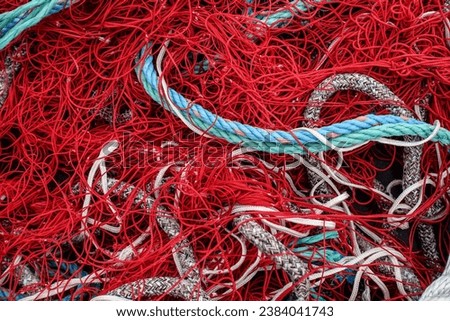 Red ropes and net on fishing boat in harbour. Chaos. Maritime background. Graphic