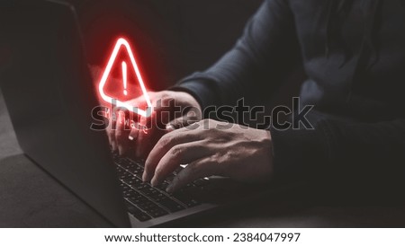 Hacker wear hood using computer laptop with red warning icon to launch ransomware malware attack on victim. Cyber security protection and hacking concept. Royalty-Free Stock Photo #2384047997