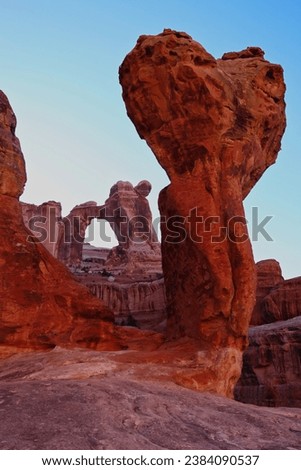 The Molar and a red sandstone cliff frames the massive Angel Arch in Canyonlands National Park Royalty-Free Stock Photo #2384090537