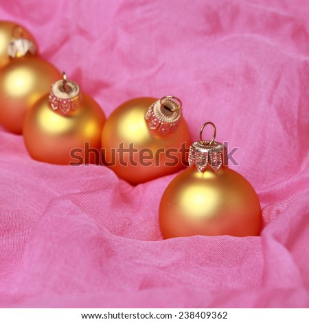 Cute christmas glass balls over pink organza fabric texture on Holiday theme