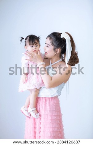 Portrait of Asian mother and child on background,Asian mom hold baby smile and kissing on baby cheek happiness moment together isolated on white background. 