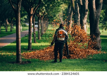 Leaf blower images set against the vibrant backdrop of autumn. These pictures capture the essence of fall cleanup, with leaves being effortlessly blown away. Ideal for projects celebrating the beauty Royalty-Free Stock Photo #2384124601