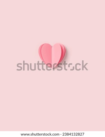 Pink paper heart on pink colored background. Minimal style flat lay, pastel monochrome colors, valentine card or wedding invitation. Handmade paper cut romantic concept, top view, close up, 3d heart
