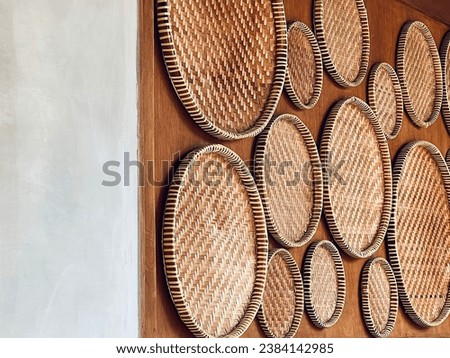 Stylish Kitchen Decor: Rice Winnower or Rice Sieve Hanging on the Wall, a fusion of culinary tradition and design from Indonesia, Thailand, Malay or South East Asia. Reference for Javanese Kitchen. Royalty-Free Stock Photo #2384142985