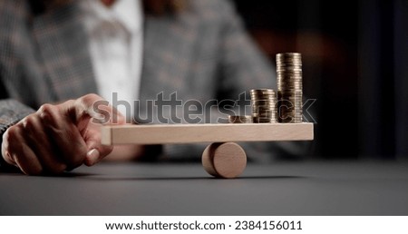 Finding Financial Balance: Leveraging Money Amid Inflation on a Seesaw Scale Royalty-Free Stock Photo #2384156011