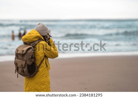 Tourist traveler photographer taking pictures landscape over north sea background
