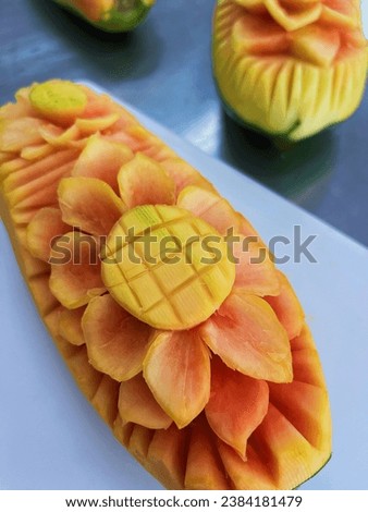 The photo of papaya carving is a picture of a beautifully carved papaya cut. These papaya pieces may have artistic patterns or amazing shapes, creating delicious and charming art.