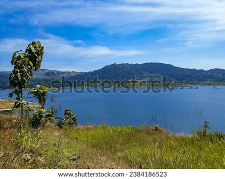 View of a wide lake with calm water in the Sumedang area, Indonesia.