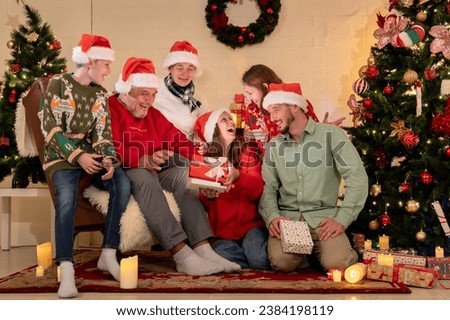 caucasian people big family celebrating christmas party in living room at home, kid girl grandchild open gift box surprise from parent celebrate festive holiday X-mas eve together in house