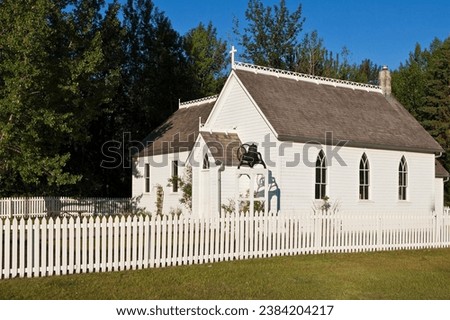 picket fence. The blooming flowers, lush greenery, and the white picket fence create a picturesque scene. Perfect for adding a touch of rustic charm to your projects, this image radiates tranquility  Royalty-Free Stock Photo #2384204217