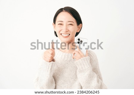 Asian middle aged woman with the smartphone thumbs up gesture in white background