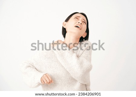 Asian middle aged woman having stiff shoulders in white background