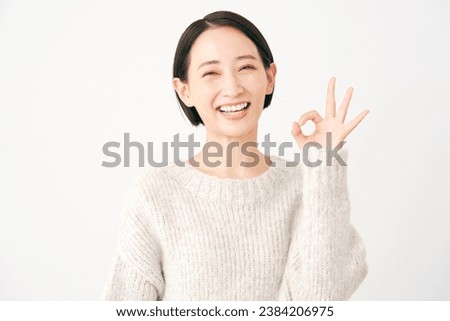 Asian middle aged woman OK gesture in white background Royalty-Free Stock Photo #2384206975