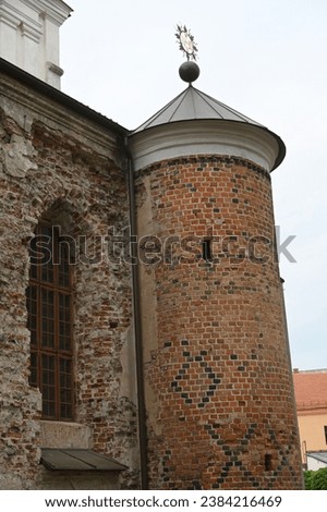 a fragment of a historic brick building with a round tower in the corner