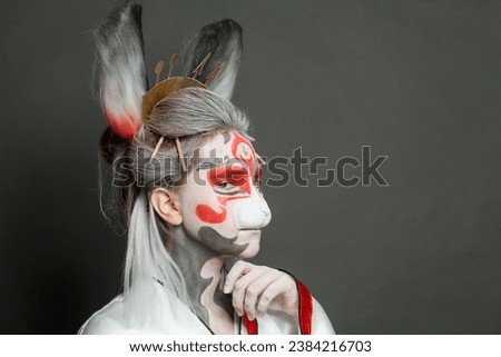 Fashion portrait of cute woman with makeup, mask and stage costume on black background with copy space, female face closeup. Halloween, carnival, performance and theater concept