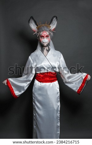 Woman actress with stage makeup in mask and kimono costume. Halloween, carnival, performance and theater concept