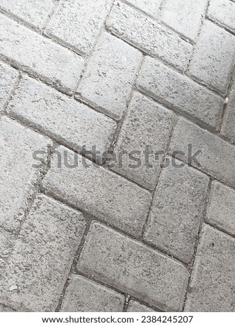 An inviting photo of neatly arranged paving stones on a sunlit day. The precise arrangement of these pavers creates a visually pleasing pattern that's perfect for any outdoor or architectural design
