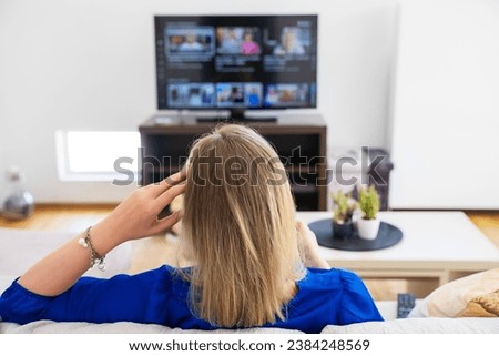 Woman watches content on her Smart TV at home.