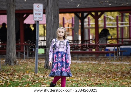 Young girl walking in the park, in front of a shelter, during a picnic in the autumn. 