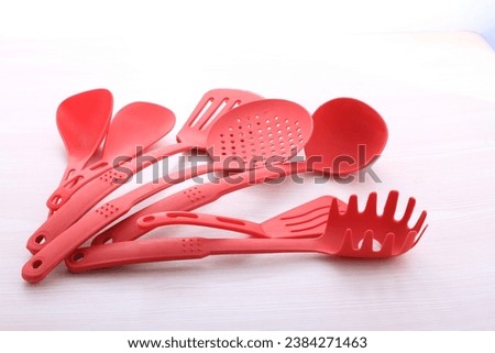 red cooking utensils on a bright background