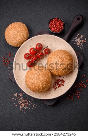 Delicious fresh crispy white round bread with seeds and grains on a dark concrete background
