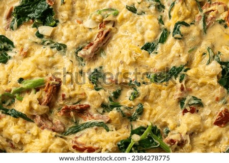 Creamy spaghetti squash pasta with parmesan cheese and sun dried tomato sauce in iron cast pan Royalty-Free Stock Photo #2384278775