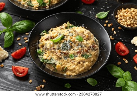 Creamy spaghetti squash pasta with parmesan cheese and sun dried tomato sauce served with pine nuts and basil. Royalty-Free Stock Photo #2384278827