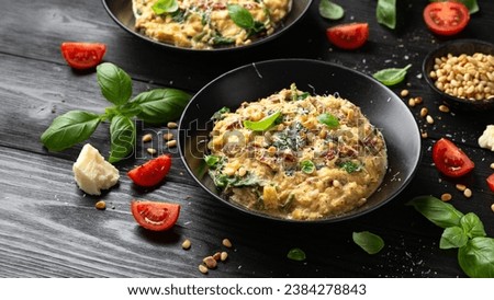 Creamy spaghetti squash pasta with parmesan cheese and sun dried tomato sauce served with pine nuts and basil. Royalty-Free Stock Photo #2384278843