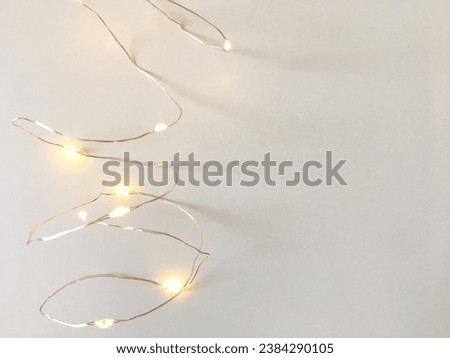 Electric garland lights on a white  background. Holiday theme. Space for text