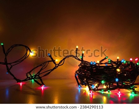 Bright lights of a twisted electric garland on a light background in the dark. Warm shades. Holiday theme