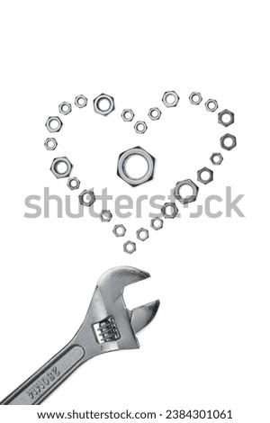 Conceptual image of a wrench and nuts on white background. Nuts are organized in the form of a heart (I Love You)