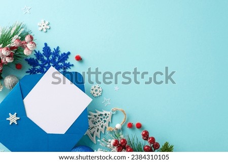 Capture the magic of Christmas. Top view of an envelope with blank paper, baubles, pine branches, holly berries, and snowflakes on a pastel blue background, ready for your message