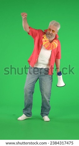 Portrait of senior hipster on Chroma key green screen background, man shows strong gesture holding megaphone. Advertising area, workspace mockup. Vertical photo.