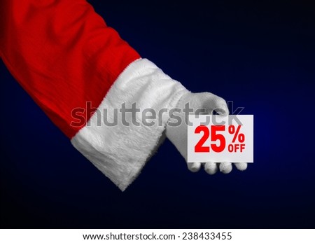 Christmas and New Year discounts topic: Hand of Santa Claus holding a white card with a 25 percent discount on an isolated dark blue background