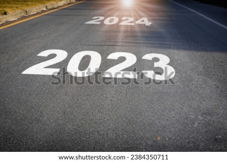 2023 to 2024 inscribed on a tarred path symbolizing the journey into the new year. Download this high resolution image for your greeting cards, social media posts, website designs, and more Royalty-Free Stock Photo #2384350711