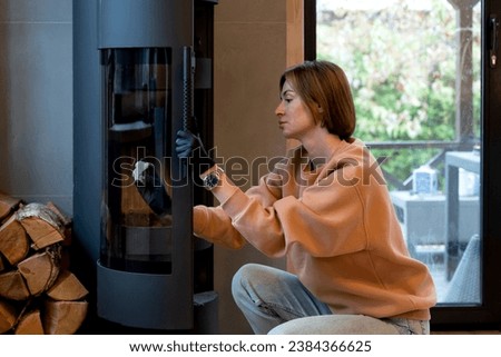 Young woman cleaning fireplace. Preparation for cold winter