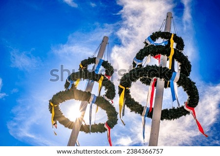 typical bavarian maypole in front of blue sky - photo