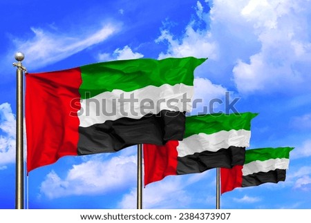 UAE Flags Waving In The Wind On A Beautiful Summer Blue Sky Royalty-Free Stock Photo #2384373907