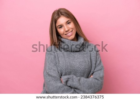 Young caucasian woman isolated on pink bakcground with arms crossed and looking forward