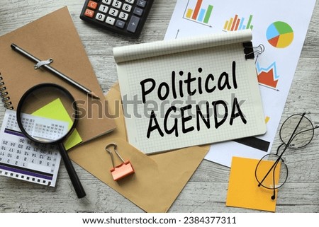 POLITICAL AGENDA, stationery and calculator on financial chart. text on notepad page with spiral