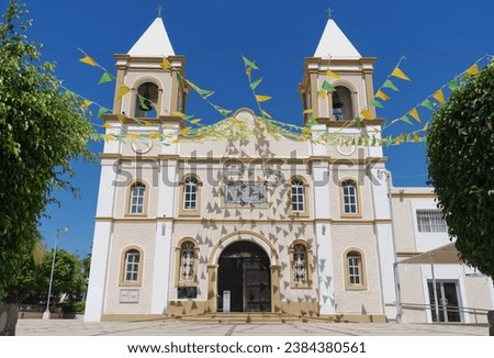 Mission San Jose del Cabo, in Baja California Sur, Mexico. Building shown decorated with strings of green and yellow triangular flags.