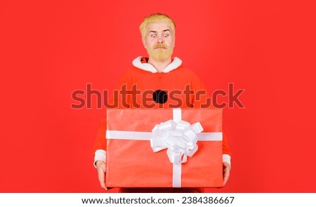Merry Christmas and Happy New Year. Delivery service. Bearded man in Santa Costume with Christmas gift box. Santa Claus with Christmas present. Christmas or New Year sales. Discount. Winter holidays.