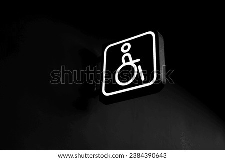 Handicapped Only. White restroom signage for persons with disabilities. White sign on black background.