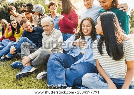 Group of multigenerational people smiling in front of camera - Multiracial friends of different ages having fun together - Main focus on senior man with white hair Royalty-Free Stock Photo #2384397791