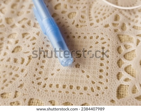 Blue translucent ballpoint pen lies on a lace napkin Royalty-Free Stock Photo #2384407989