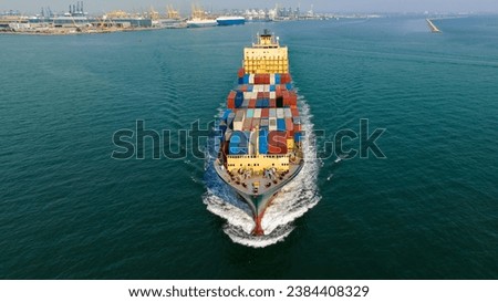 cargo container shipping sailing in sea import export logistic goods and distributing products to dealerand consumers across worldwide, by container ship Transport, business service. front view drone  Royalty-Free Stock Photo #2384408329