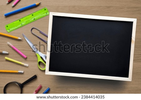 Template with copy space. School or business theme. Flat lay. Blank Chalkboard on background of desk with stationery. Place for text.