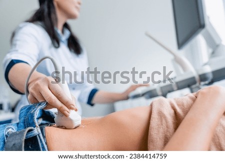 Close up of female doctor doing ultrasound probe on patient stomach in medical clinic. Gastritis prevention. Pregnancy, maternity concept. Ovulation period Royalty-Free Stock Photo #2384414759