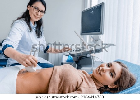 Portrait of woman getting ultrasound from doctor. Gastritis and digestion problems prevention. Pregnancy ovulation female health gynecologist health checkup Royalty-Free Stock Photo #2384414783
